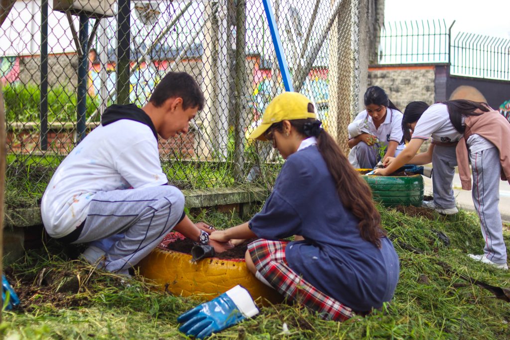 Dos jovenes sembrando un arbol